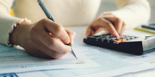 Closeup woman filling form of Individual Income Tax Return,
